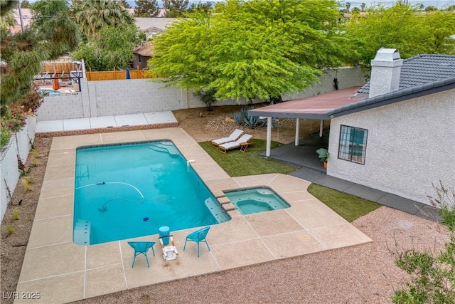view of pool with a patio, a fenced backyard, and a pool with connected hot tub