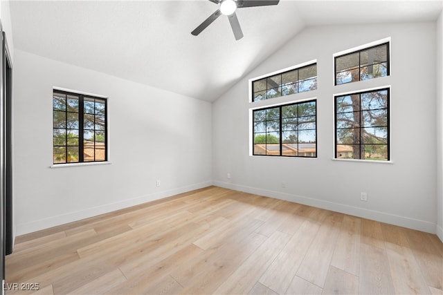 spare room with ceiling fan, light wood finished floors, baseboards, and high vaulted ceiling