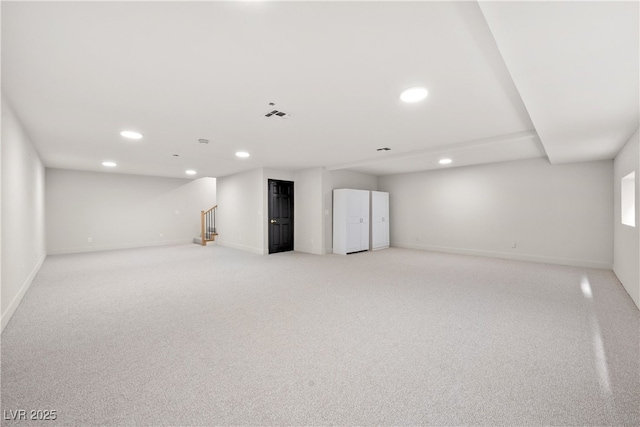 finished basement with recessed lighting, light colored carpet, stairs, and baseboards