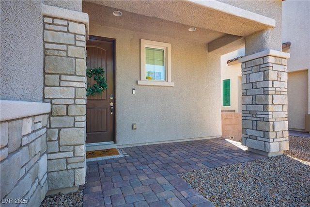 doorway to property featuring stucco siding