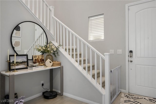 staircase featuring wood finished floors and baseboards