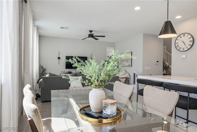 dining space with ceiling fan, wood finished floors, recessed lighting, and stairway