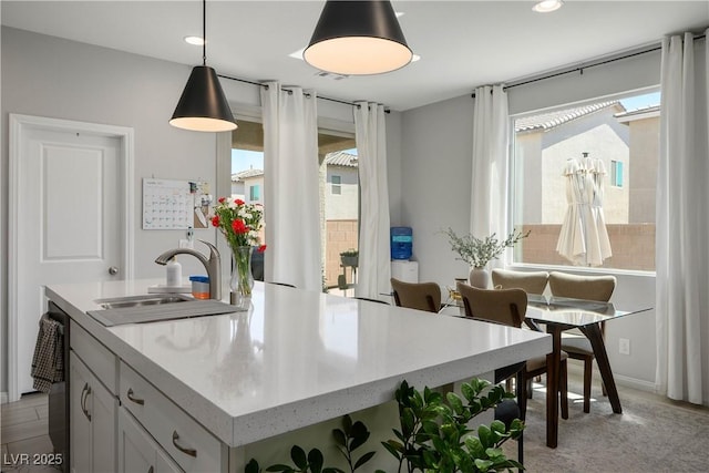 kitchen with a sink, pendant lighting, recessed lighting, a kitchen island with sink, and white cabinetry