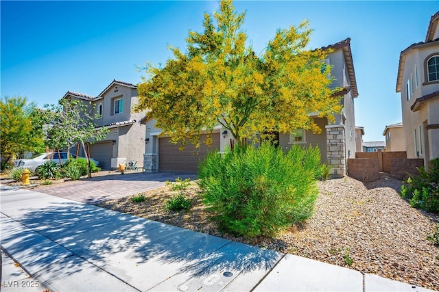 view of front of house featuring stucco siding, driveway, and fence