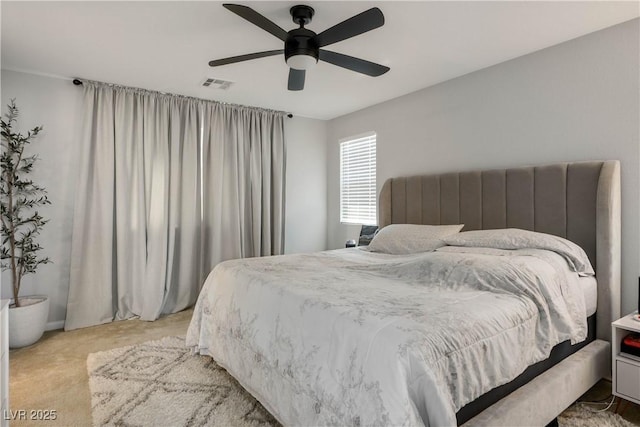 bedroom featuring light colored carpet and a ceiling fan