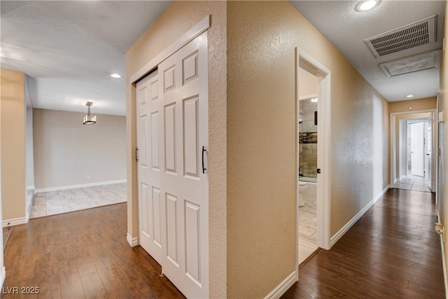 6117 Foxcroft Ave, Las Vegas, NV 89108 - hall with dark wood-type flooring, a textured wall, baseboards, and recessed lighting