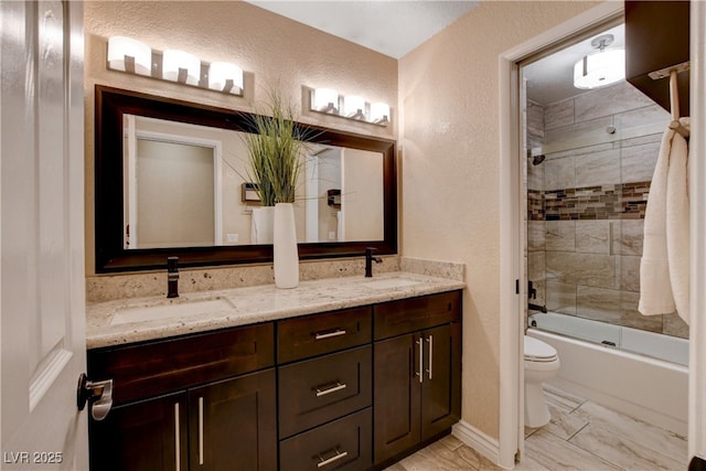 6117 Foxcroft Ave, Las Vegas, NV 89108 - full bath with toilet, a textured wall, double vanity, and combined bath / shower with glass door