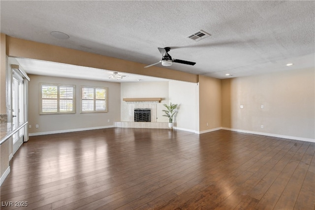 6117 Foxcroft Ave, Las Vegas, NV 89108 - unfurnished living room featuring ceiling fan, dark wood-style flooring, a textured ceiling, a tile fireplace, and baseboards