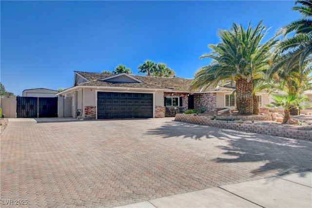 6117 Foxcroft Ave, Las Vegas, NV 89108 - ranch-style home featuring a garage, decorative driveway, a gate, and brick siding