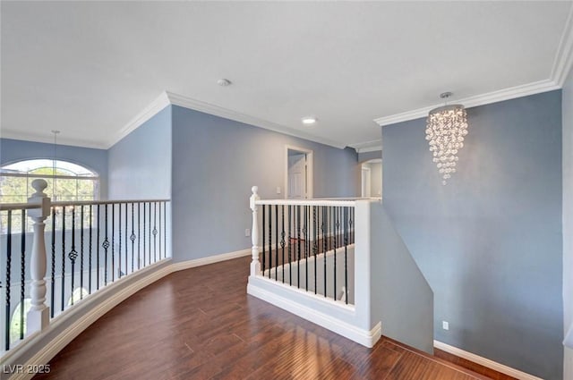 hallway featuring an upstairs landing, wood finished floors, a chandelier, baseboards, and ornamental molding