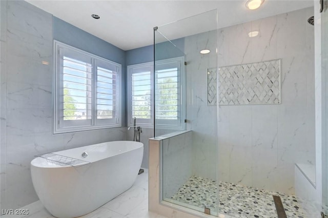 full bath featuring marble finish flooring, a marble finish shower, and a soaking tub