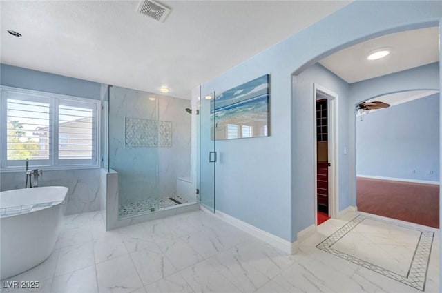 full bath with a marble finish shower, marble finish floors, a freestanding bath, and baseboards