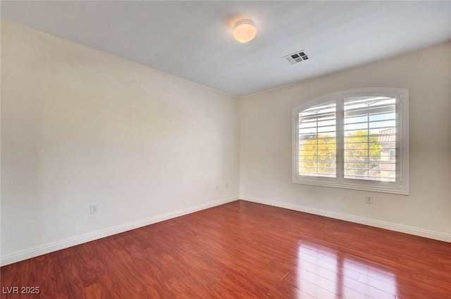 unfurnished room with wood finished floors and baseboards