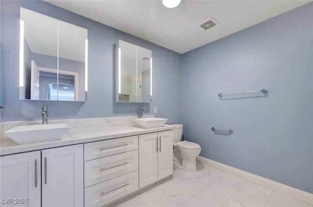 bathroom featuring marble look tiles, toilet, baseboards, double vanity, and a shower