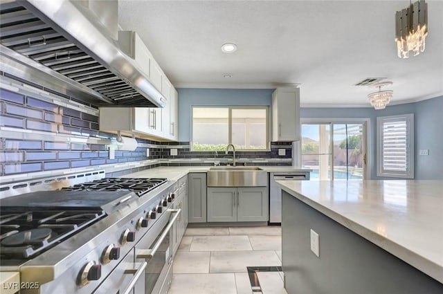 kitchen with appliances with stainless steel finishes, extractor fan, a sink, gray cabinetry, and light countertops