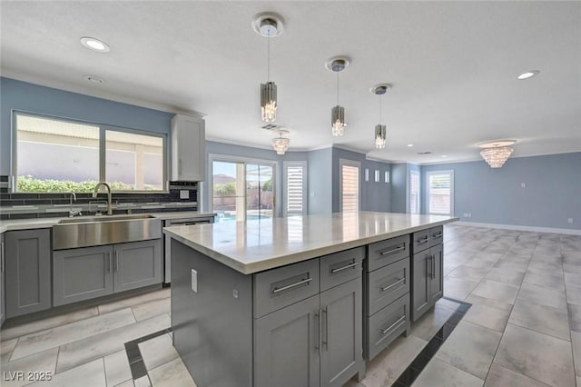 kitchen featuring gray cabinets, a sink, recessed lighting, a kitchen island, and tasteful backsplash