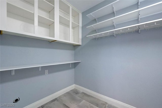 spacious closet with marble look tile flooring