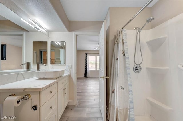 bathroom featuring curtained shower, vanity, a ceiling fan, and baseboards