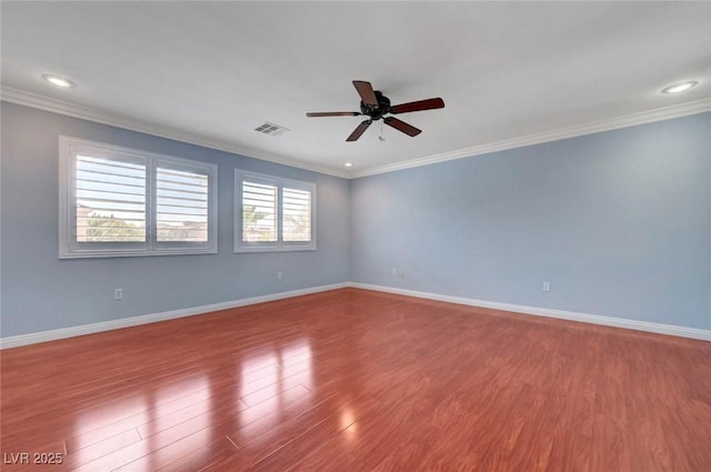 empty room with a ceiling fan, crown molding, wood finished floors, baseboards, and recessed lighting