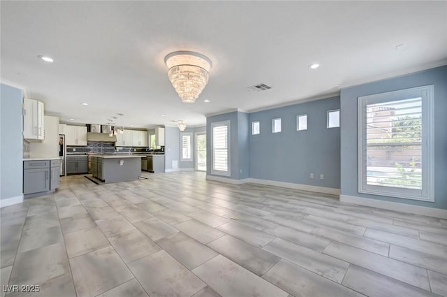 unfurnished living room featuring recessed lighting, a chandelier, and baseboards