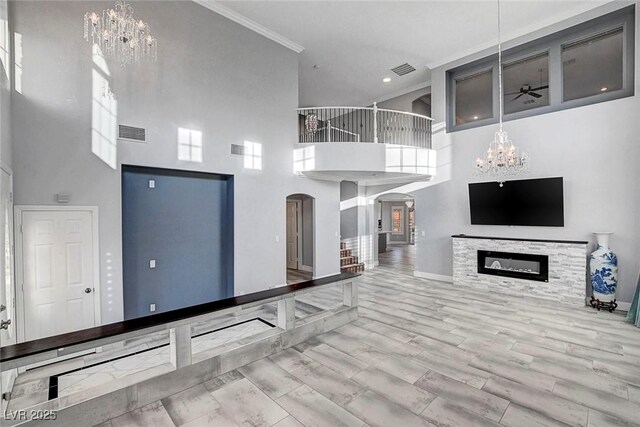 281 Powerbilt Ave, Las Vegas, NV 89148 - unfurnished living room with a chandelier, arched walkways, a high ceiling, baseboards, and recessed lighting