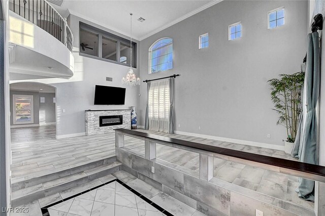 281 Powerbilt Ave, Las Vegas, NV 89148 - kitchen with a high ceiling, baseboards, crown molding, a fireplace, and healthy amount of natural light