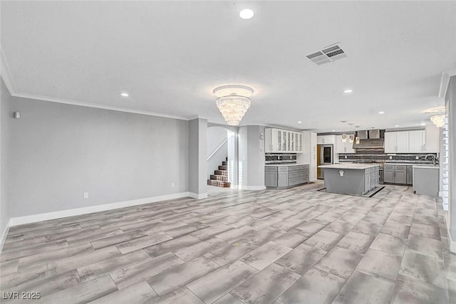 281 Powerbilt Ave, Las Vegas, NV 89148 - unfurnished living room featuring recessed lighting, crown molding, baseboards, stairway, and a sink