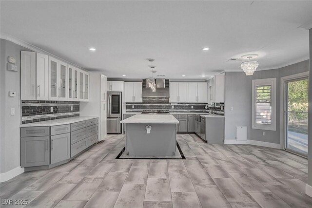 281 Powerbilt Ave, Las Vegas, NV 89148 - kitchen with appliances with stainless steel finishes, gray cabinetry, light countertops, a kitchen island, and decorative backsplash