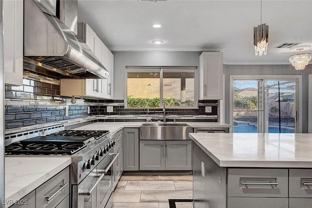 281 Powerbilt Ave, Las Vegas, NV 89148 - kitchen featuring gray cabinetry, double oven range, a sink, wall chimney range hood, and ornamental molding
