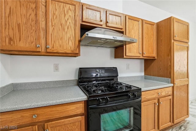 kitchen with gas stove, under cabinet range hood, light countertops, and brown cabinets