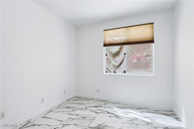 unfurnished room featuring light marble finish floors and baseboards