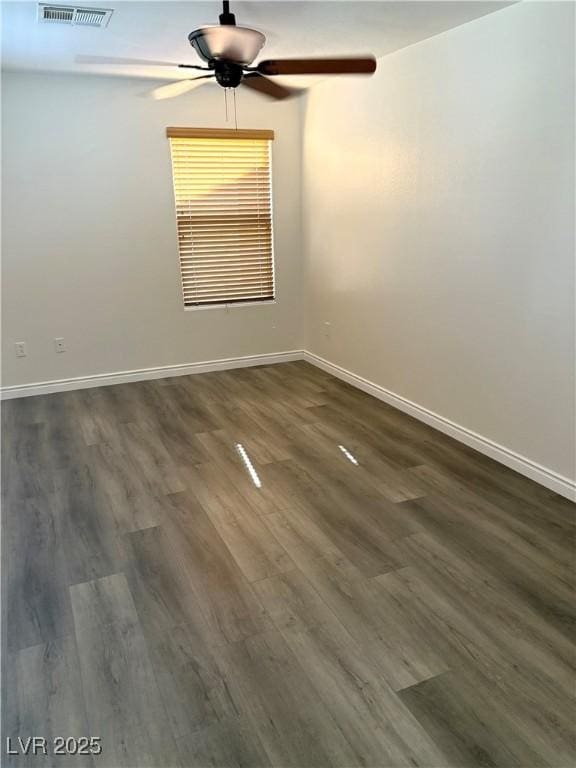 empty room featuring ceiling fan, baseboards, and dark wood-style floors