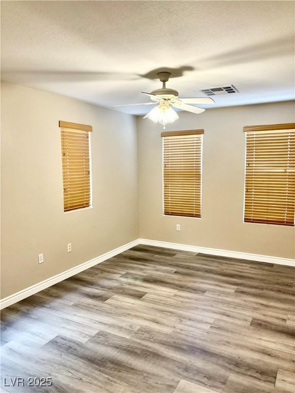 spare room featuring baseboards, a ceiling fan, and wood finished floors