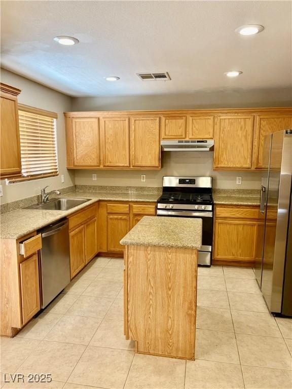 kitchen featuring stainless steel appliances, a sink, under cabinet range hood, a center island, and recessed lighting