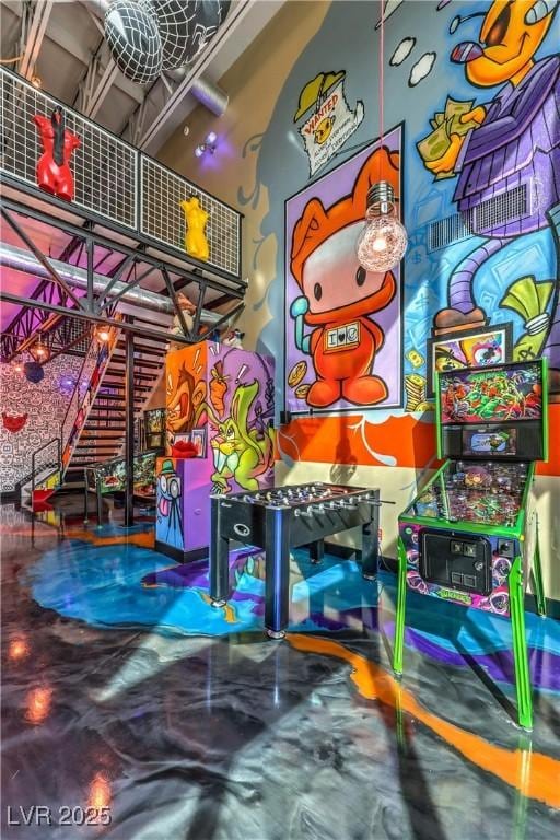 game room featuring a towering ceiling