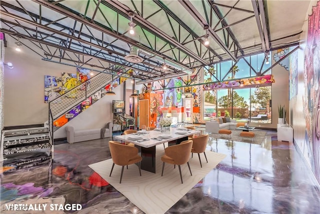 dining space featuring a high ceiling and baseboards