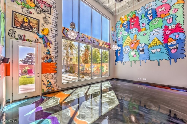 interior space featuring a towering ceiling and healthy amount of natural light