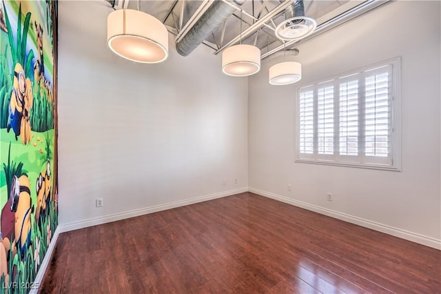 empty room featuring wood finished floors and baseboards