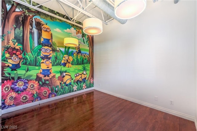 spare room featuring baseboards and wood finished floors