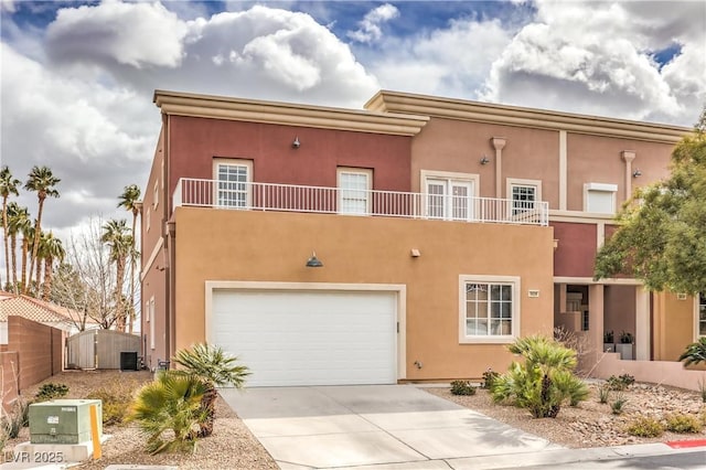 view of front of property with a garage, stucco siding, concrete driveway, and fence