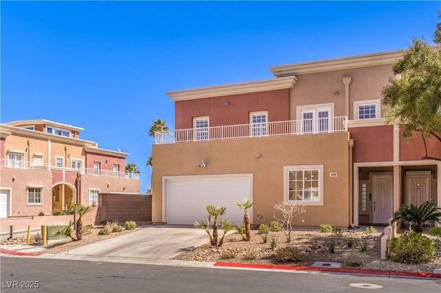 view of front of home featuring a garage, driveway, stucco siding, and fence