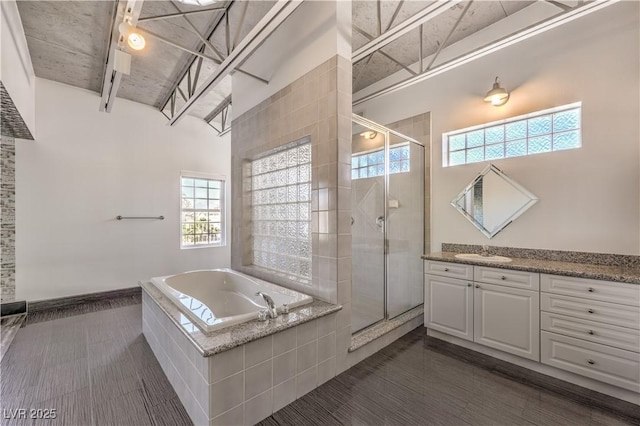 bathroom with a shower stall, vanity, a bath, healthy amount of natural light, and a high ceiling