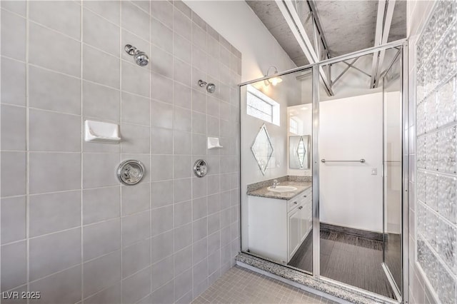 full bathroom featuring a tile shower and vanity