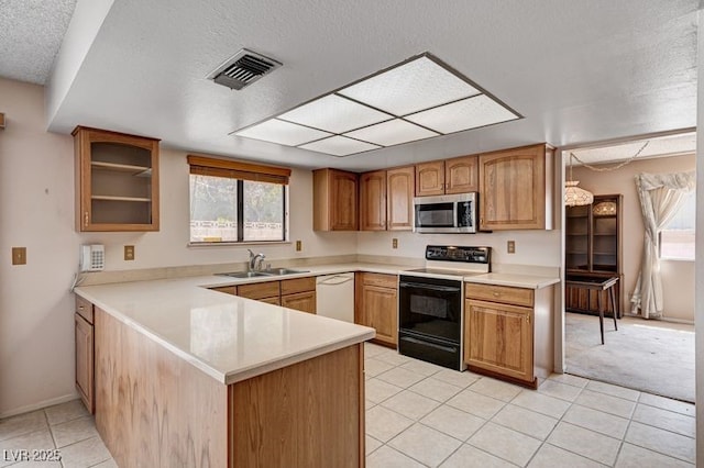 kitchen featuring stainless steel microwave, range with electric cooktop, dishwasher, a sink, and a textured ceiling