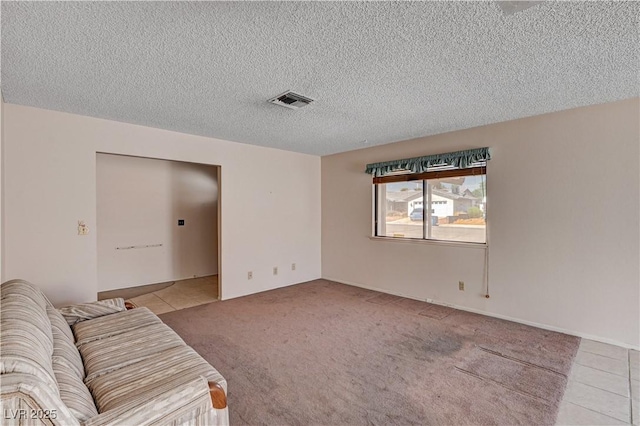 unfurnished living room with a textured ceiling, light carpet, and light tile patterned floors