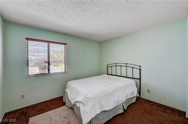 carpeted bedroom with a textured ceiling and baseboards