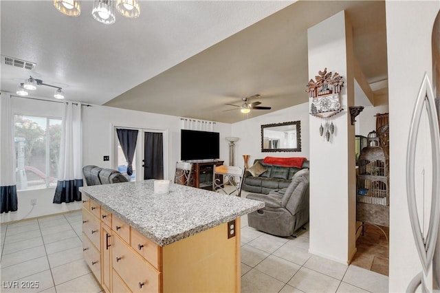 5220 Shasta Daisy St, North Las Vegas, NV 89031 - kitchen featuring light brown cabinetry, light tile patterned flooring, open floor plan, a ceiling fan, and a center island
