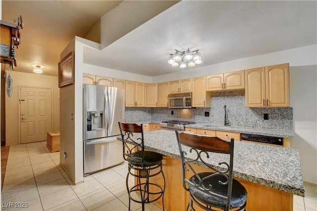 5220 Shasta Daisy St, North Las Vegas, NV 89031 - kitchen with stainless steel appliances, a sink, light brown cabinets, light tile patterned floors, and tasteful backsplash