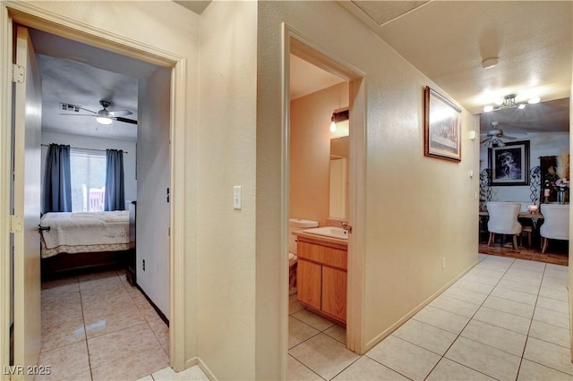 5220 Shasta Daisy St, North Las Vegas, NV 89031 - hallway with light tile patterned floors, baseboards, and a sink