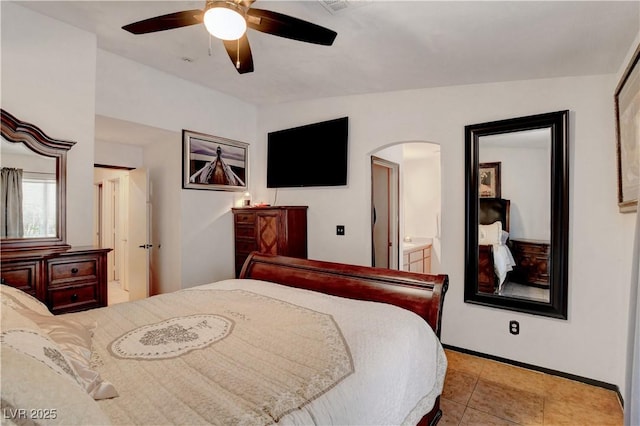 5220 Shasta Daisy St, North Las Vegas, NV 89031 - bedroom with arched walkways, baseboards, connected bathroom, ceiling fan, and tile patterned floors